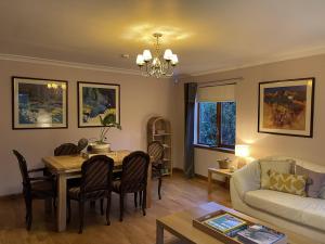 a living room with a table and a couch at Foxglove Cottages in Drymen