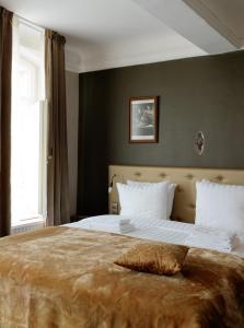 a bedroom with a large bed with a pillow on it at Boutique Hotel Grote Gracht in Maastricht