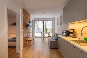 a kitchen and living room with a couch and a table at Karkonosky Apartamenty - Izery in Szklarska Poręba