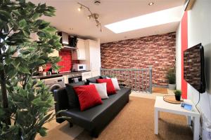 a living room with a black couch and a brick wall at Northcote Lane Apartments by Property Promise in Cardiff