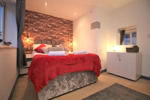- une chambre avec un grand lit et un mur en briques dans l'établissement Northcote Lane Apartments by Property Promise, à Cardiff