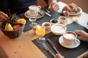 una mesa de madera con desayuno de café y fruta en Chalet Caminetto, en Vason