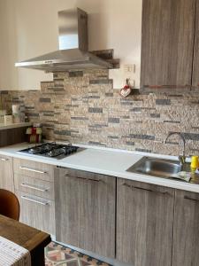 a kitchen with a sink and a brick wall at Casa vacanza sole lago… in Intra