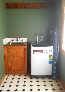 a kitchen with a sink and a washing machine at Red Brier Cottage Accommodation in Richmond