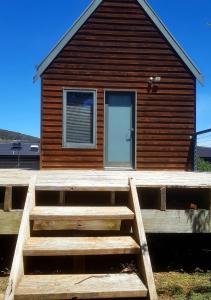 una casa de madera con una gran terraza de madera delante de ella en Red Brier Cottage Accommodation, en Richmond