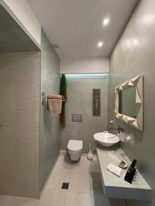 a bathroom with a sink and a toilet and a shower at Raffinato Suite (Cielo suites) in Kavála