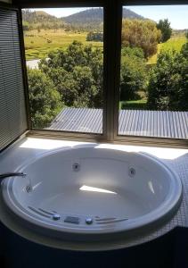 eine große Badewanne in einem Zimmer mit Fenster in der Unterkunft Red Brier Cottage Accommodation in Richmond