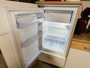 an empty refrigerator with its door open in a kitchen at Ferienwohnung in Kuppenheim für 1 bis 2 Personen in Kuppenheim