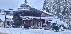 a building covered in snow with a stop sign at The Green King in Borovets