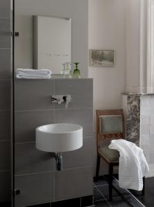 a bathroom with a sink and a chair and a mirror at Boutique Hotel Grote Gracht in Maastricht