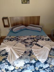 a bed with two pillows on it with two sheets at Varandas do Atalaia Suítes in Arraial do Cabo