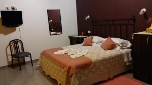 Un dormitorio con una cama con toallas. en Kawo Apart Hotel, en Puerto Santa Cruz
