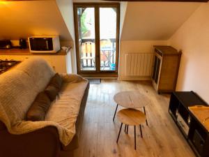 a living room with a couch and a table at Appartement Cosy 600m Gare - étage 3 - balcon et calme - TV - wifi in Bernay