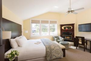 a bedroom with a bed and a desk and a fireplace at Healdsburg Inn on the Plaza, A Four Sisters Inn in Healdsburg