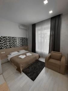 um quarto com uma cama grande e uma cadeira em Premier em Yaremche