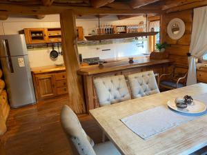 a kitchen and dining room with a table and a refrigerator at ROTUI CABAÑA EXCLUSIVA DON FERMIN in San Martín de los Andes