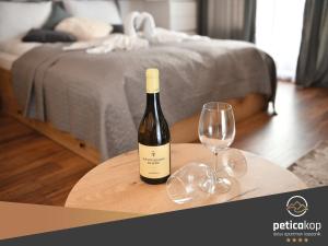 Una botella de vino sentada en una mesa con una copa de vino en Apartman PETICA KOP A8 Kopaonik en Kopaonik