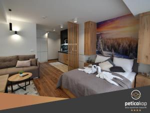 科帕奧尼克的住宿－Apartman PETICA KOP A8 Kopaonik，一间卧室,床上有两只白色动物