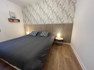 a bedroom with a bed with two pillows on it at Superbe appartement en Centre ville d'ARRAS in Arras