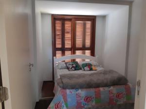 a small bed in a room with a window at Lugar encantador com bela paisagem in Bagé