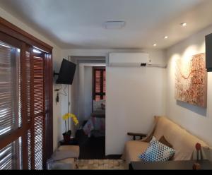 a living room with a couch and a television at Lugar encantador com bela paisagem in Bagé