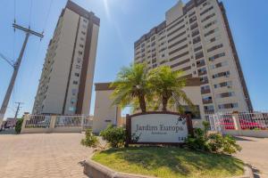 a sign in front of two tall buildings at Apartamento em ótima localização in Torres