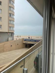 een uitzicht op het strand vanuit een raam van een gebouw bij Northastic Suite in Oostende