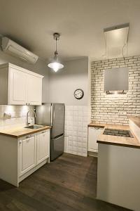 cocina con armarios blancos y nevera de acero inoxidable en Old Town Apartment, en Cracovia