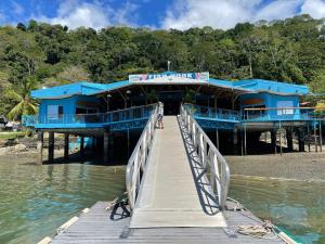 a blue building on a pier over the water at Fish Hook Marina Hotel in Golfito
