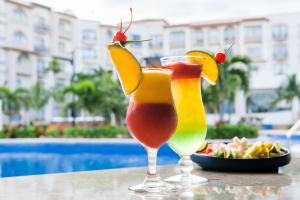 een drankje op een tafel naast een bord eten bij Fiesta Americana Cancun Villas in Cancun