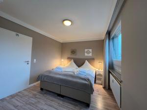 ein Schlafzimmer mit einem Bett und einem großen Fenster in der Unterkunft Muschelsucher in Westerland