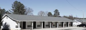 a white building with a gray roof at Bar-Mel Inn in McCormick