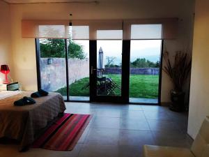 um quarto com uma cama e uma grande porta de vidro em Mirador del Alto Jujuy em San Salvador de Jujuy