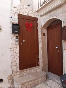 uma porta castanha com um laço vermelho em Mastropaolo42 Luxury B&B em Grottaglie