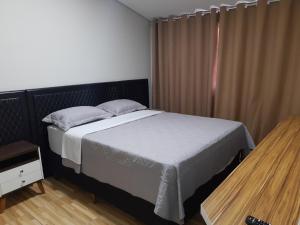 a bedroom with a large bed and a window at MEDIEVAL HOTEL II in Três Corações