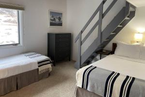 a bedroom with two beds and a staircase at Woodbridge 29E in Snowmass Village