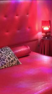 a red bedroom with a bed with a red head board at La Mazmorra de Lucifer in Madrid