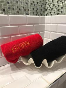 a red and black towel on a shelf in a bathroom at La Mazmorra de Lucifer in Madrid