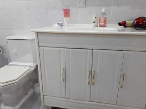 a bathroom with a white sink and a toilet at Apartamento completo A42 Flat Centro in Mogi das Cruzes