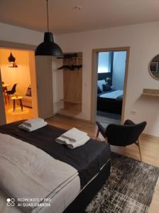 een slaapkamer met een bed met een stoel en een spiegel bij Apartman Relax in Ðakovo