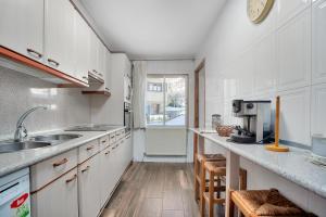 a kitchen with white cabinets and a sink at CASA PELAIRE - Wifi, barbacoa, pistas 4 min a pie in Panticosa