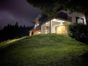カルタゴにあるArte de Plumas birding lodgeの夜の丘の上の家