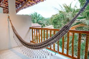 a hammock on the balcony of a house at Vila Baiana Pousada in Itacaré