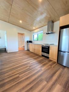 a large kitchen with wooden floors and stainless steel appliances at Country Retreats on Ranzau 8 in Hope