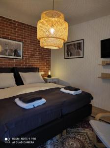 a bedroom with a bed with a brick wall at Studio apartman Relax in Đakovo