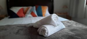 una pila de toallas blancas sentadas encima de una cama en VILLA CATANIA, en Búzios
