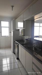 a kitchen with a sink and a stove top oven at Apartamento Beira mar in Arroio do Silva