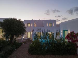 a white house with a garden in front of it at Majo Suites Hotel in Agia Anna Naxos
