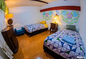 1 dormitorio con 2 camas y mesa con lámpara en Bull House, en Urubamba