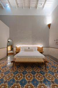 a bedroom with a large bed and a rug at DECU DOWNTOWN in Mérida